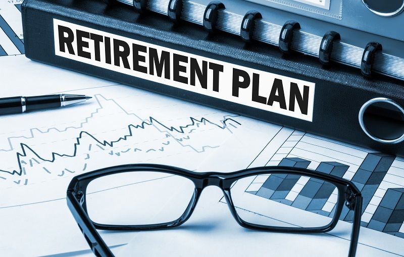 Retirement plan with graphs and glasses on desk comp