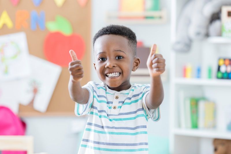 Adorable boy gives thumbs up in preschool cm