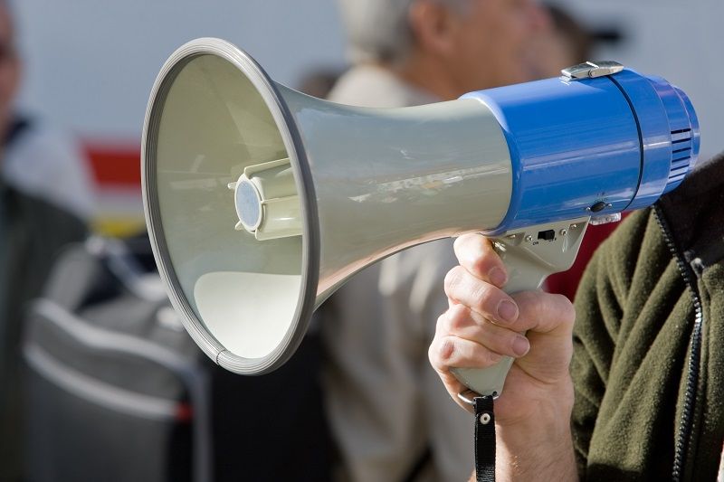 Blue megaphone being held in an action position cm