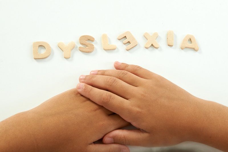 hands of a girl form the word dyslexia cm