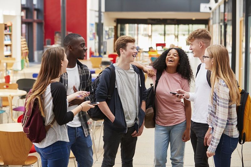 Student Group Socializing In Communal Area Of Busy College cm