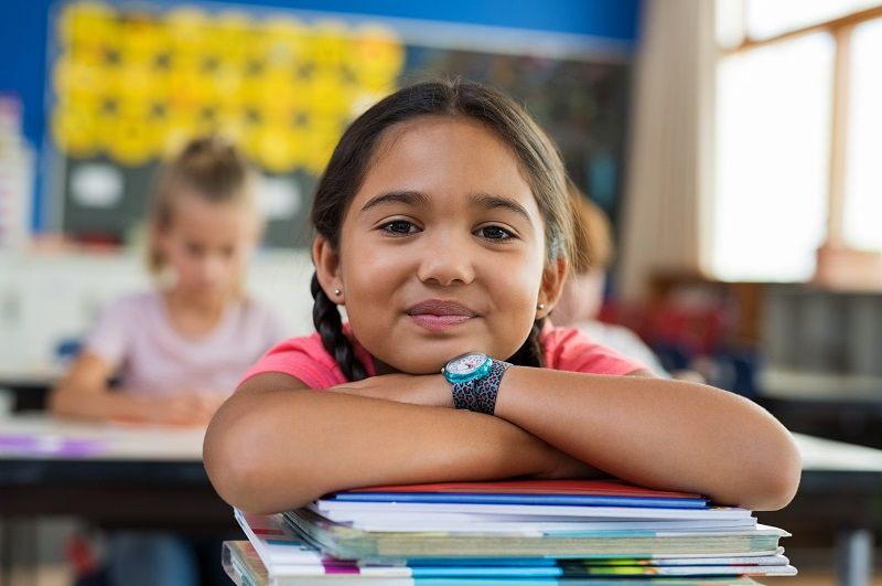 Hispanic girl with chin on books cm