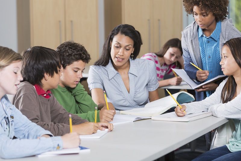 Teacher helping students in classroom cm