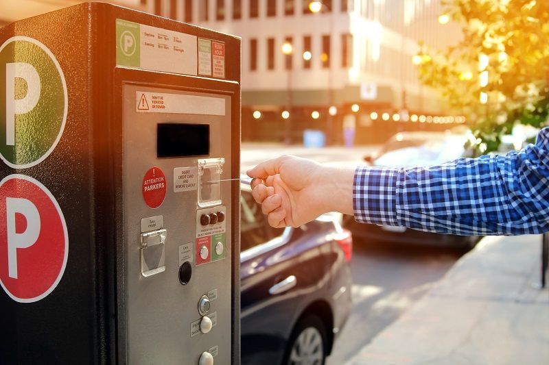 man is paying his parking using credit card at parking pay station terminal cm