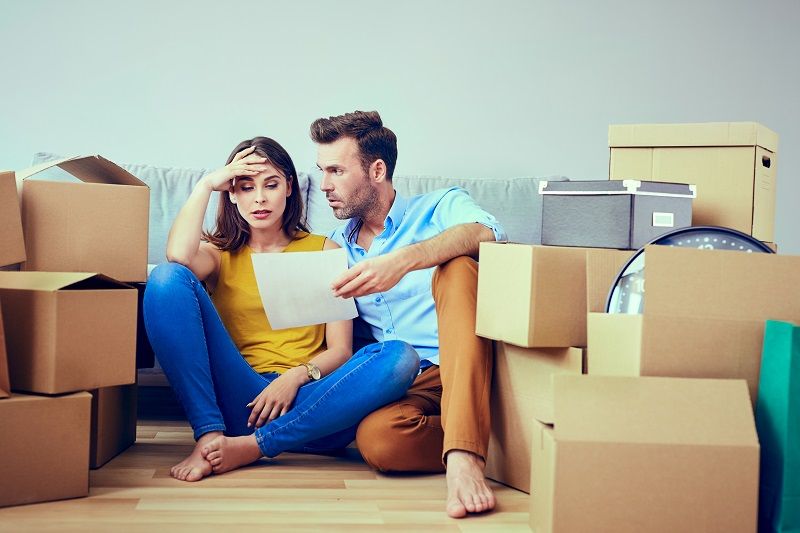 Worried couple reading agreement after moving to new home cm