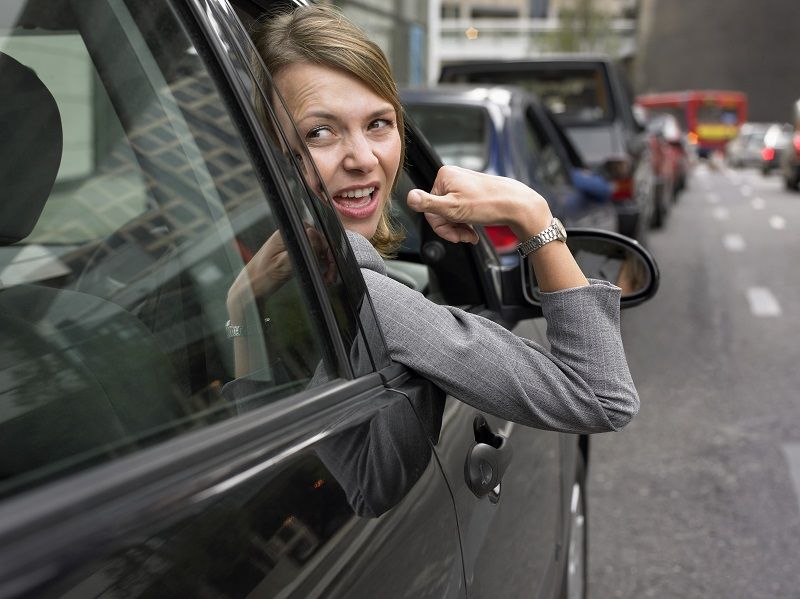 Woman Sitting in Her Car in a Traffic Jam Looking Back and Gesturing With Frustration cm