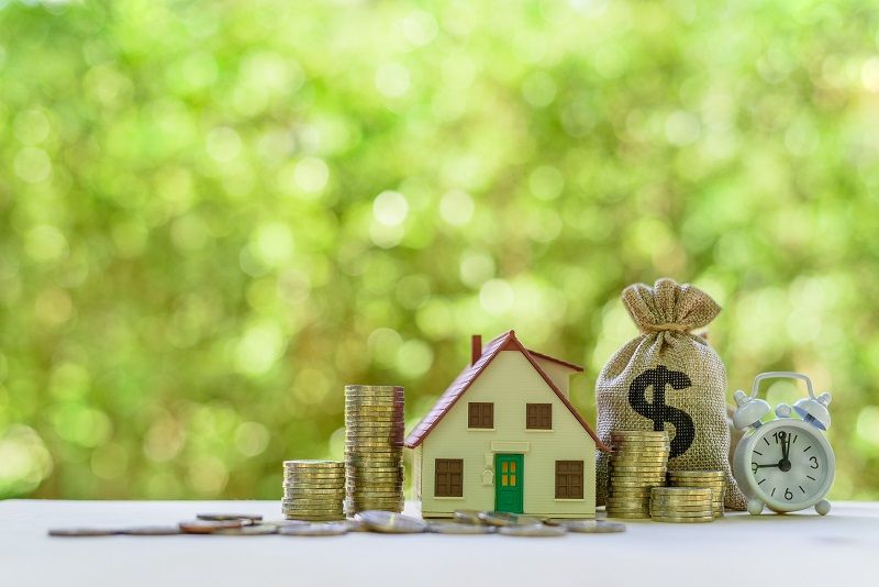 Residential real estate loan financial concept House model coins US dollar bag white clock on a table depicts home loan or borrowing money to buy cm