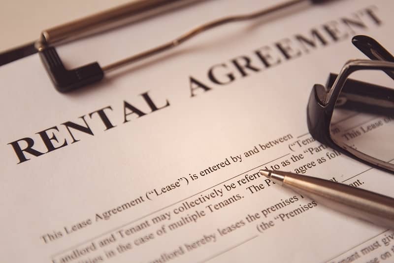 Business legal document concept Pen and glasses on a rental agreement form cm